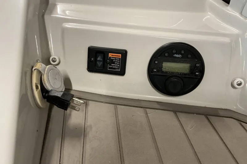 Slide: The Image of 2021 Crownline Eclipse E255 boat dashboard with control panel and power outlet. - 35