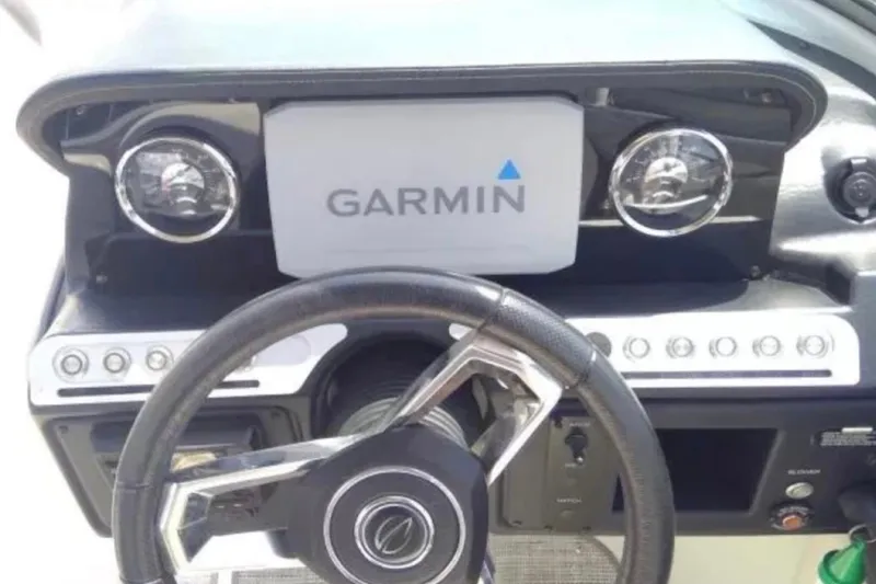 Slide: The Image of Steering wheel and Garmin display on 2021 Crownline Eclipse E255 boat dashboard. - 40