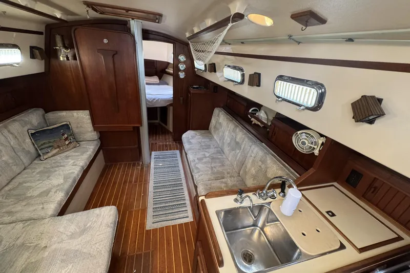 Slide: The Image of Interior of a 1994 Island Packet 32 sailboat with cozy seating and wooden finishes. - 14