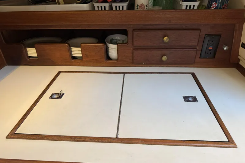 Slide: The Image of Interior of 1994 Island Packet 32 sailboat galley with wooden cabinetry and storage compartments. - 17