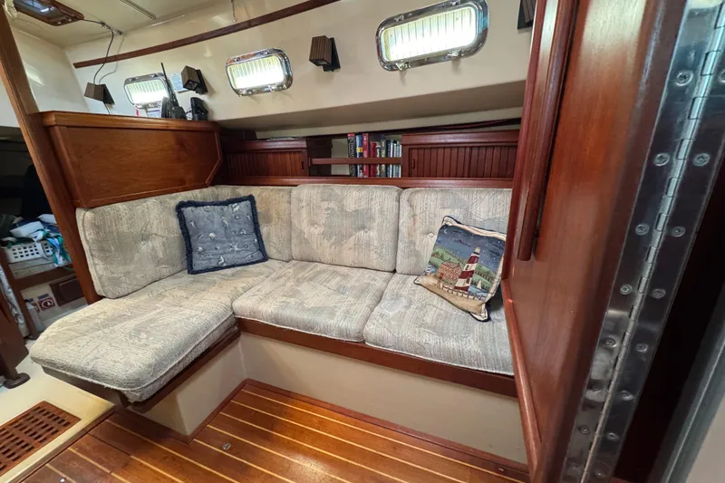 Slide: The Image of Cozy interior of 1994 Island Packet 32 sailboat with cushioned seating and nautical decor. - 18