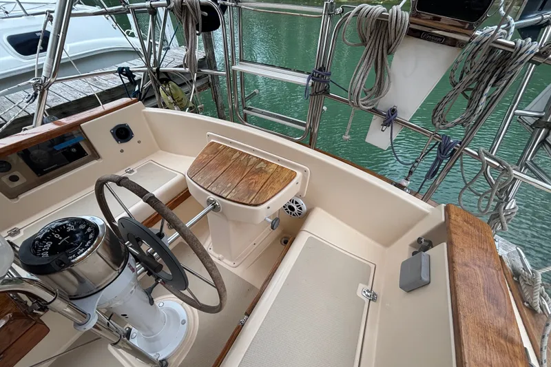 Slide: The Image of Cockpit of 1994 Island Packet 32 sailboat with wooden accents and steering wheel. - 23