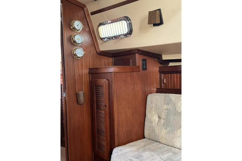 Slide: The Image of Interior of 1994 Island Packet 32 sailboat with wooden cabinetry and nautical instruments. - 23