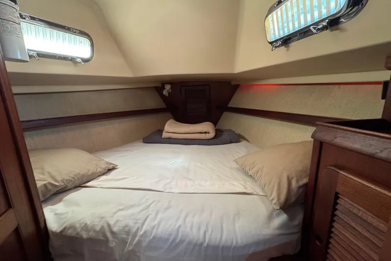 Slide: The Image of Cozy cabin interior of a 1994 Island Packet 32 sailboat with comfortable bedding. - 27