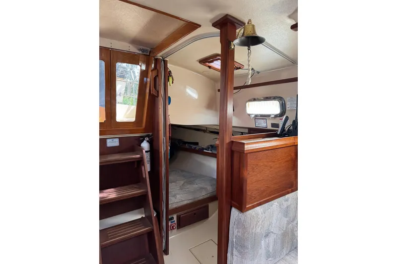 Slide: The Image of Interior of a 1994 Island Packet 32 sailboat, featuring wooden finishes and cozy cabin space. - 28
