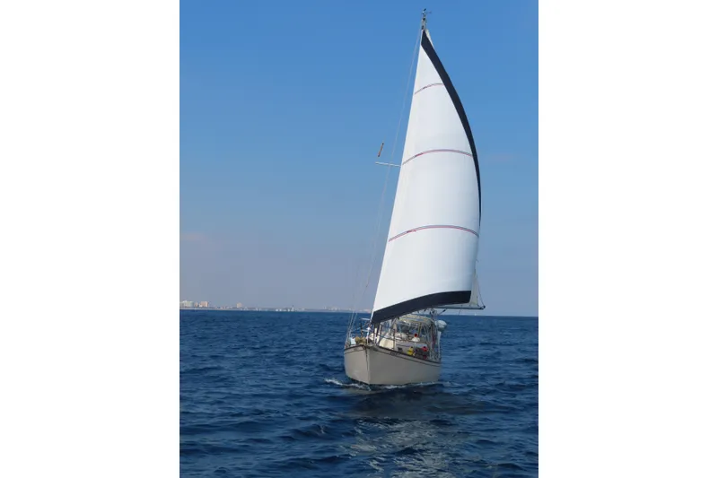 Slide: The Image of Sailing yacht Island Packet 32 (1994) gliding on open sea under clear blue sky. - 4