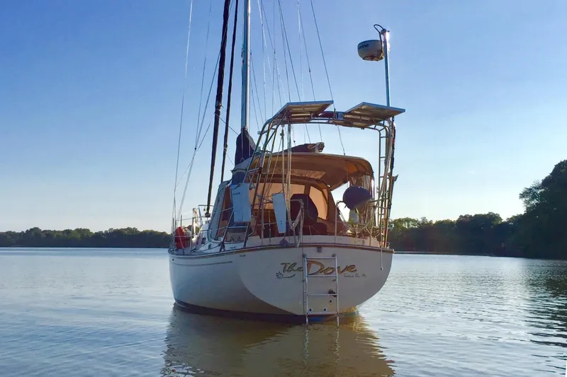 Slide: The Image of 1994 Island Packet 32 sailboat on calm water. - 7