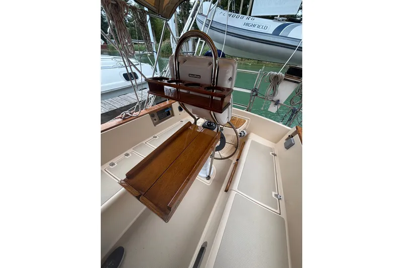 Slide: The Image of 1994 Island Packet 32 sailboat cockpit with wooden table and steering wheel. - 24