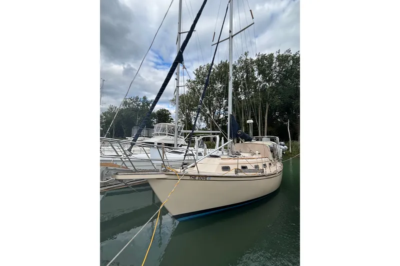 Slide: The Image of 1994 Island Packet 32 sailboat docked in a serene marina setting. - 8