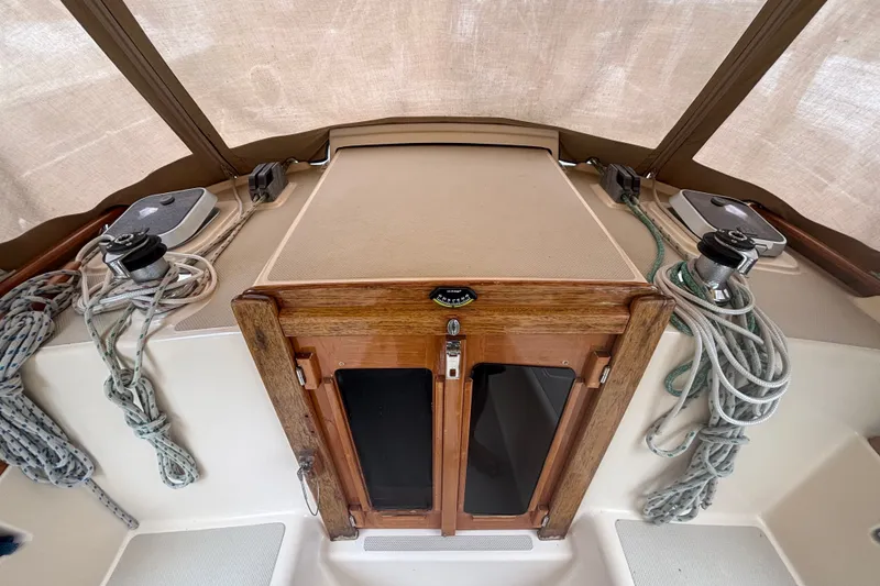 Slide: The Image of Cockpit of 1994 Island Packet 32 sailboat with ropes and wooden hatch. - 32