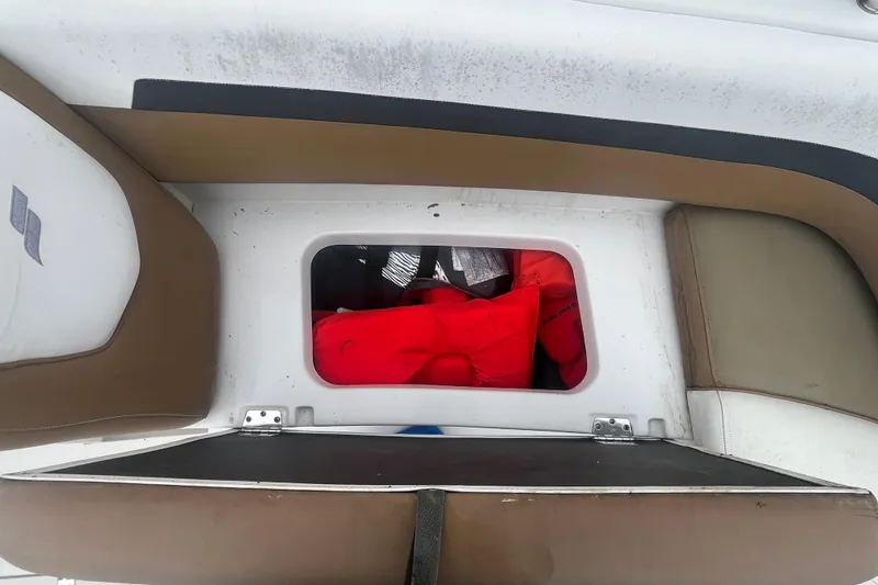 Slide: The Image of Storage compartment in a 2021 Starcraft SVX 211 OB boat with life jackets inside. - 12