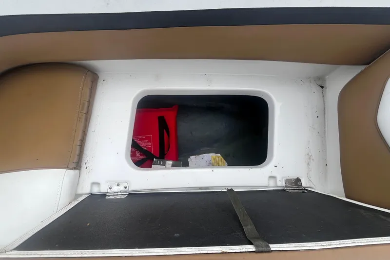 Slide: The Image of Storage compartment in a 2021 Starcraft SVX 211 OB boat with brown and white seating. - 14