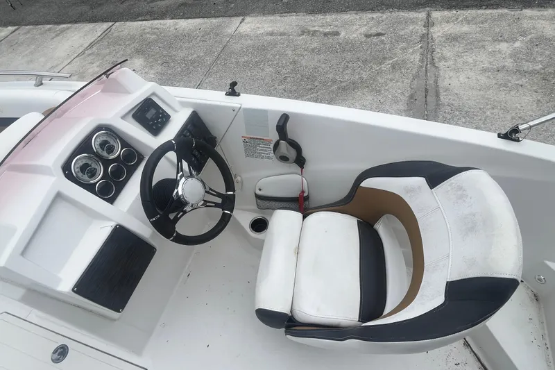 Slide: The Image of 2021 Starcraft SVX 211 OB boat cockpit with steering wheel and captain's chair. - 17