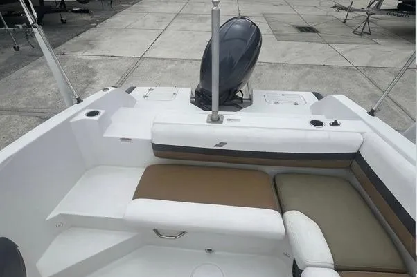 Slide: The Image of 2021 Starcraft SVX 211 OB boat interior with cushioned seating and outboard motor. - 24