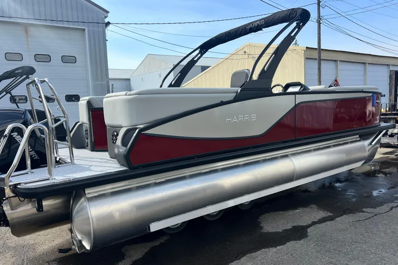 Slide: The Image of 2026 Harris Sunliner 230 pontoon boat with sleek red and white design, docked outdoors. - 14