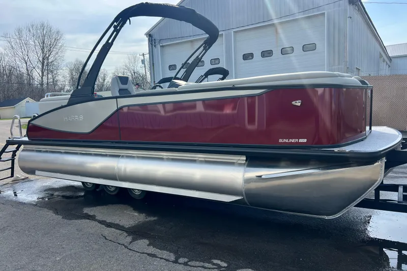 Slide: The Image of 2026 Harris Sunliner 230 pontoon boat with sleek design, parked outdoors. - 15