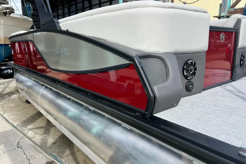 Slide: The Image of 2026 Harris Sunliner 230 pontoon boat with red and gray exterior, docked. - 9