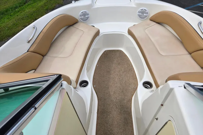 Slide: The Image of 2011 Sea Ray 200 Sundeck interior with tan seating and carpeted floor. - 10