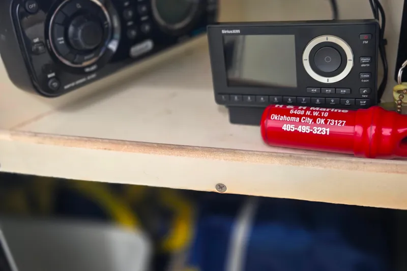 Slide: The Image of Shelf with SiriusXM radio and red safety whistle on a 2011 Sea Ray 200 Sundeck. - 16