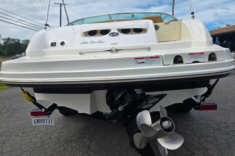 Slide: The Image of 2011 Sea Ray 200 Sundeck boat rear view with propeller and license plate visible. - 2