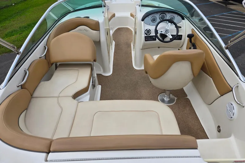 Slide: The Image of Interior of 2011 Sea Ray 200 Sundeck boat with beige seating and steering console. - 20