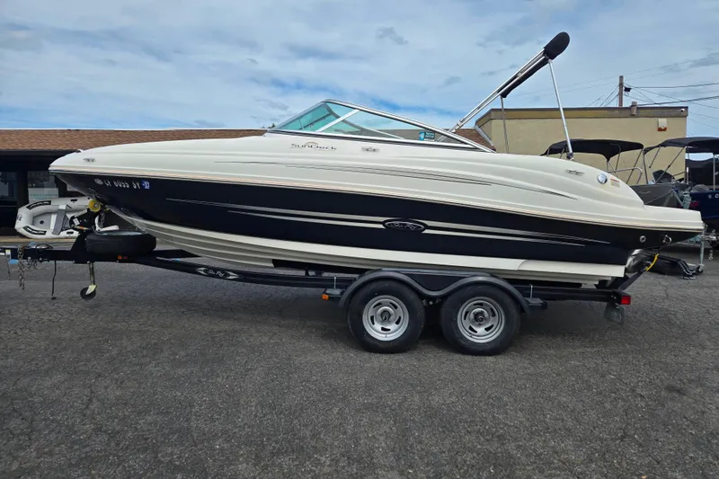 Slide: The Image of 2011 Sea Ray 200 Sundeck boat on trailer, parked outdoors. - 5