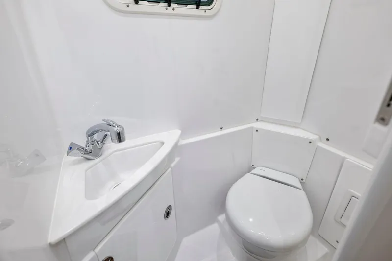 Slide: The Image of Compact bathroom in 2026 Everglades 375 Center Console boat, featuring sink and toilet. - 21