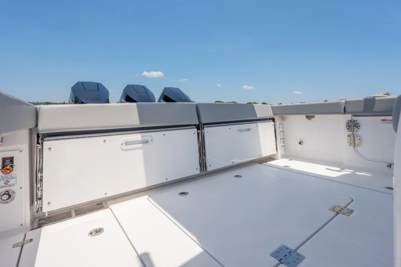 Slide: The Image of 2026 Everglades 375 Center Console boat deck with storage compartments and outboard motors. - 16