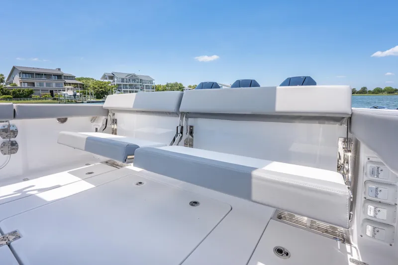 Slide: The Image of 2026 Everglades 375 Center Console boat interior with seating, docked near waterfront homes. - 17