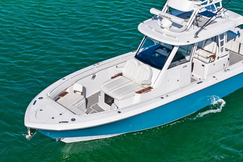 Slide: The Image of 2026 Everglades 375 Center Console boat cruising on clear blue water. - 7