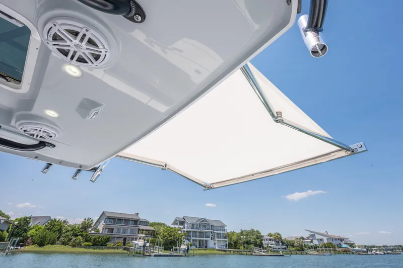 Slide: The Image of 2026 Everglades 375 Center Console boat with canopy, speakers, and waterfront view. - 14