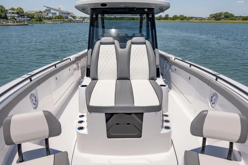 Slide: The Image of 2026 Everglades 375 Center Console boat interior with luxurious seating on a calm lake. - 7