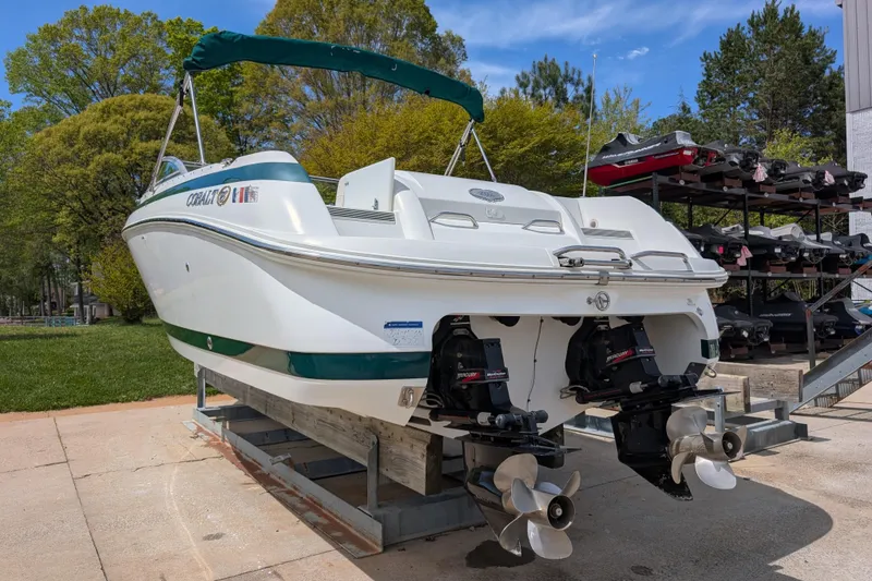 Slide: The Image of 2000 Cobalt 292 boat on a lift, featuring dual propellers, surrounded by trees. - 5
