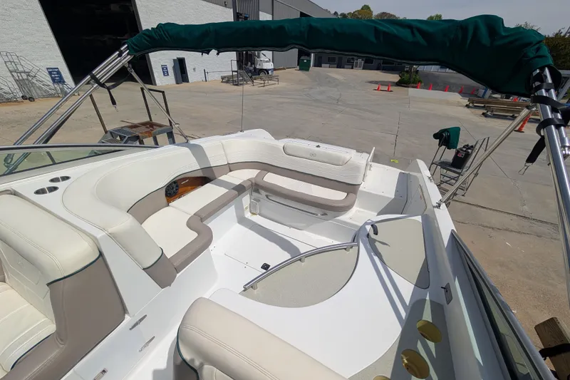 Slide: The Image of 2000 Cobalt 292 boat interior with white seating and green canopy in a marina setting. - 7