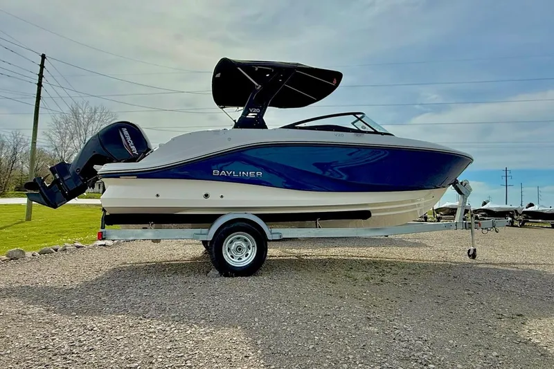 The Image of 2026 Bayliner V20 boat on trailer, blue and white design, parked outdoors. - 1