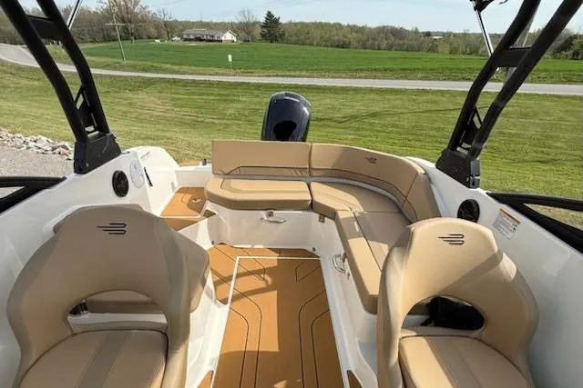 Slide: The Image of 2026 Bayliner V20 boat interior with tan seating and open deck, set against a grassy landscape. - 11