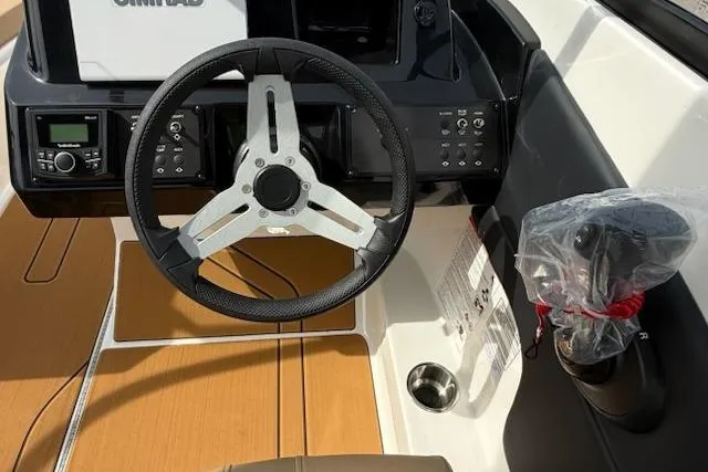 Slide: The Image of Steering wheel and dashboard of 2026 Bayliner V20 boat, featuring modern controls and wood accents. - 8