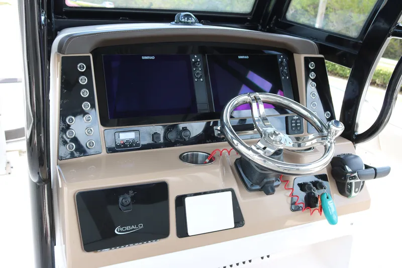 Slide: The Image of 2021 Robalo R272 Center Console dashboard with dual Simrad displays and steering wheel. - 11