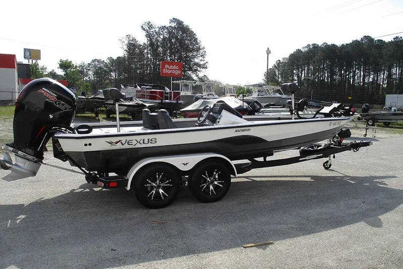 Slide: The Image of 2021 Vexus AVX 1980 boat on trailer, parked outdoors near storage facility. - 2