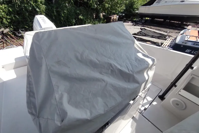 Slide: The Image of Covered equipment on a 2023 RYCK 280 boat deck, surrounded by greenery and other boats. - 55