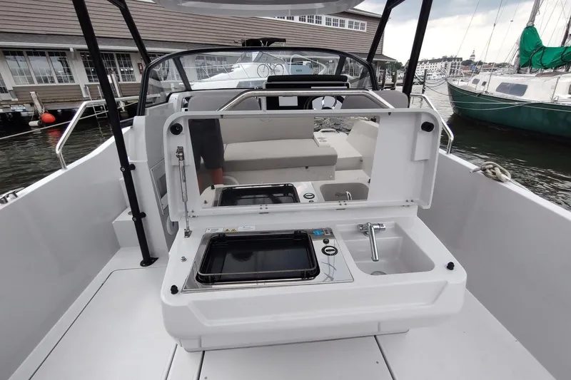 Slide: The Image of RYCK 280 boat interior with kitchenette, featuring stove and sink, docked at marina, 2023 model. - 17