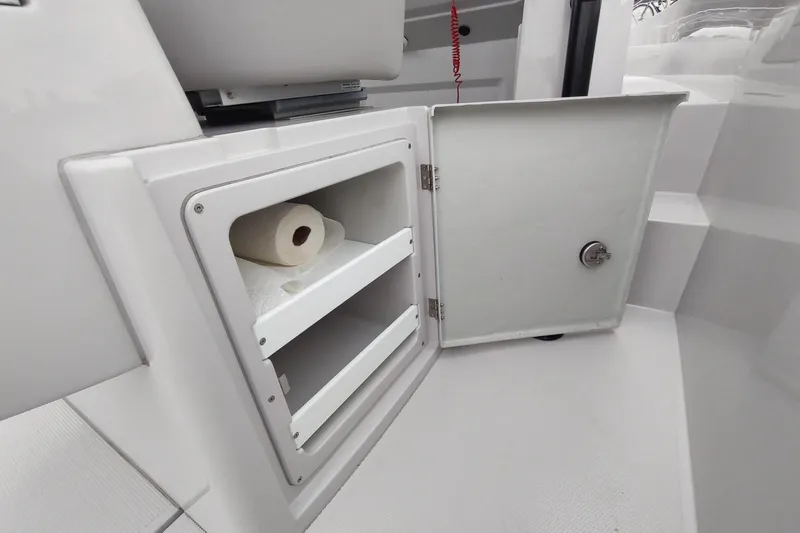 Slide: The Image of Open storage compartment on 2023 RYCK 280 boat with paper towel roll inside. - 36