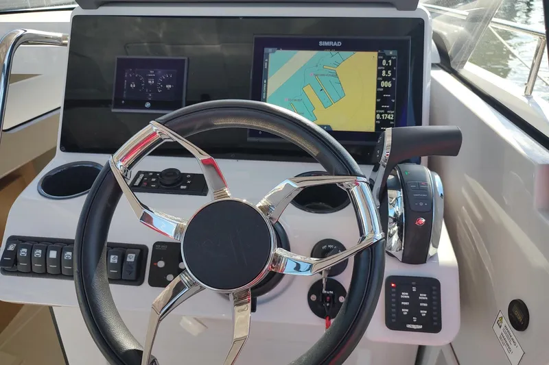 Slide: The Image of Steering wheel and navigation system of 2023 RYCK 280 boat, featuring Simrad display. - 21