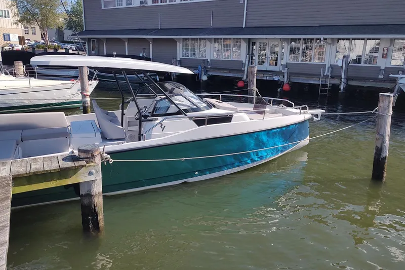 Slide: The Image of Modern 2023 RYCK 280 boat docked at a marina, featuring sleek design and vibrant blue hull. - 2