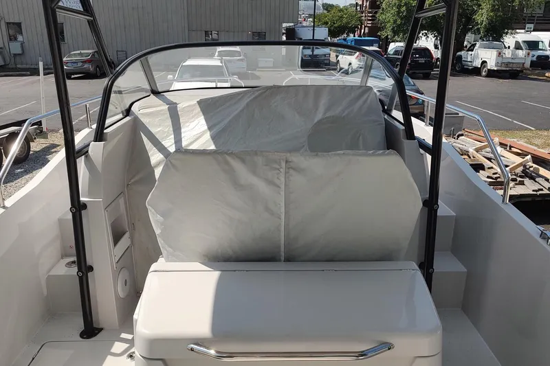 Slide: The Image of RYCK 280 boat interior, 2023 model, featuring covered seating and sleek design in a parking area. - 54