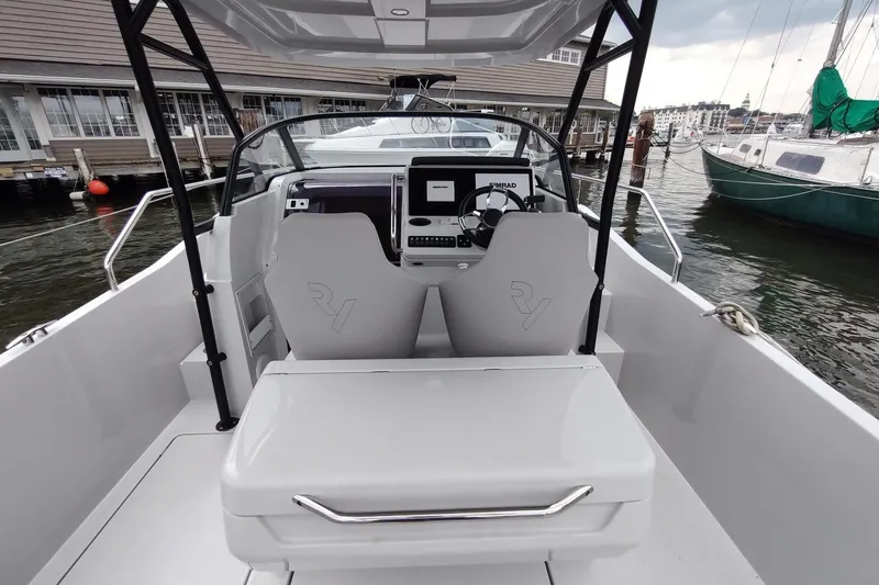 Slide: The Image of 2023 RYCK 280 boat interior with modern helm and seating, docked at marina. - 16