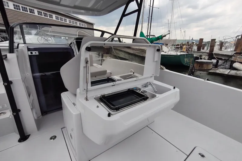 Slide: The Image of RYCK 280 boat interior with modern kitchenette, docked at marina, 2023 model. - 18