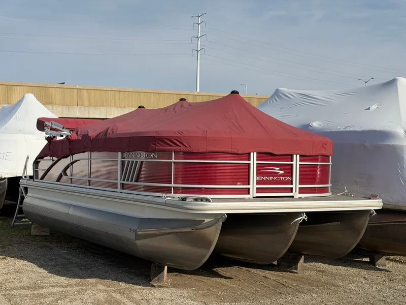 The Image of 2022 Bennington 20 LSB pontoon boat with red cover in storage. - 0