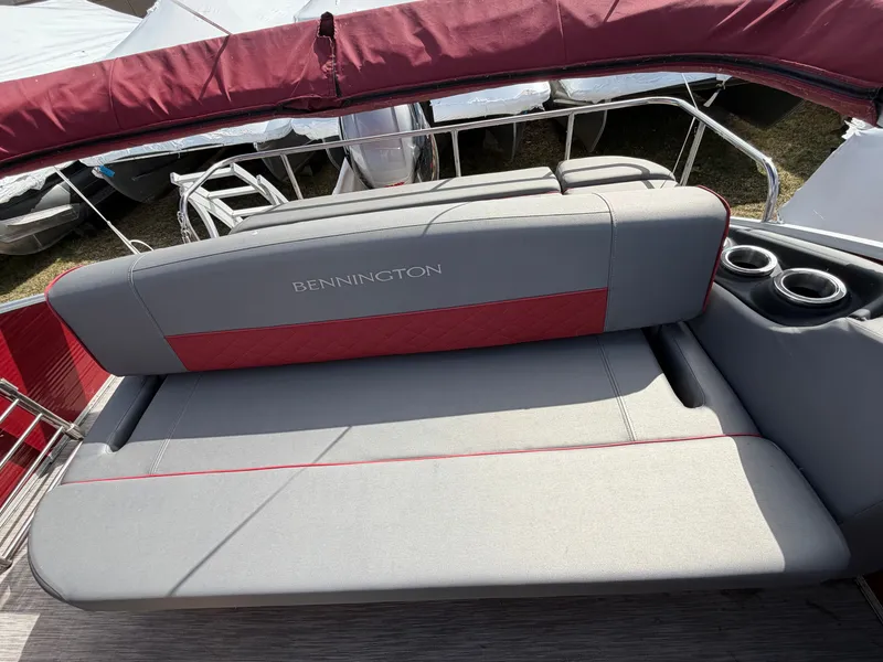 Slide: The Image of Bennington 20 LSB 2022 boat seat with red accents and cup holders. - 3