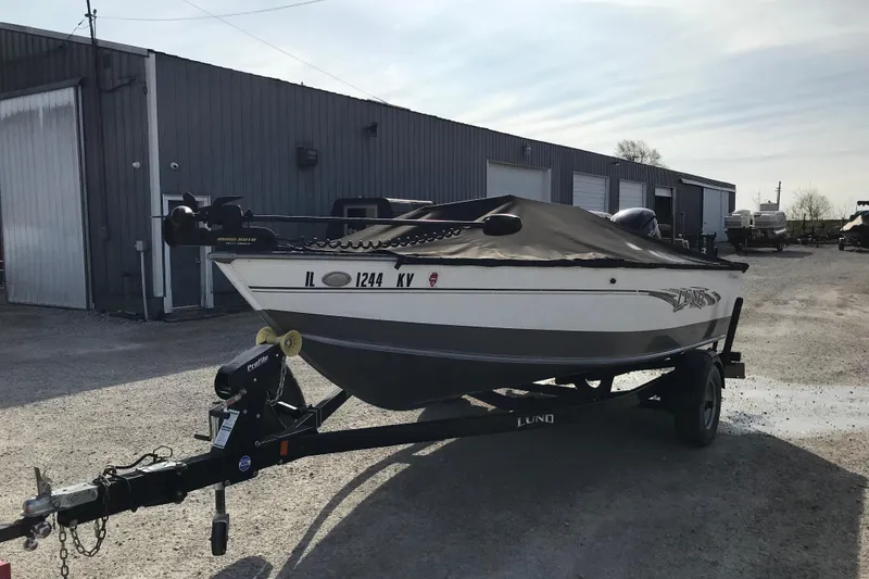 Slide: The Image of 2017 Lund 1775 Impact SS boat on trailer, parked outside a warehouse. - 6